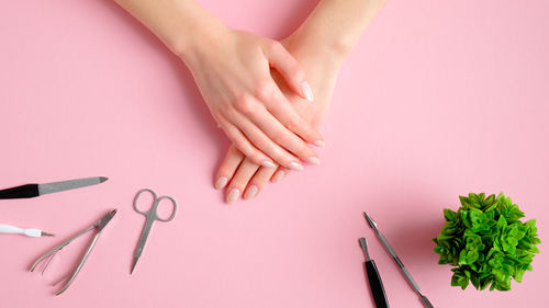 High angle view of woman hand over pink background