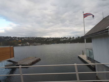 Scenic view of river by buildings against sky