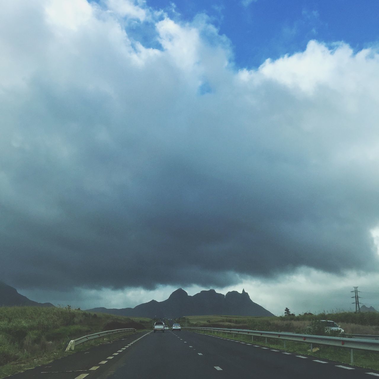 EMPTY ROAD WITH MOUNTAINS IN BACKGROUND