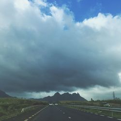 Empty road against cloudy sky