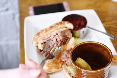 Close-up of hand holding food in plate