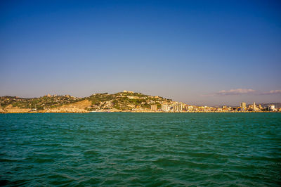 Scenic view of sea against sky in city