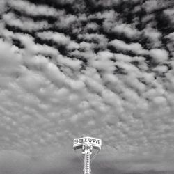 Low angle view of pole against cloudy sky