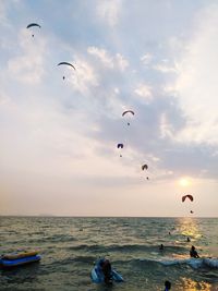 People in sea against sky