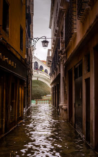 Canal amidst buildings against sky in city