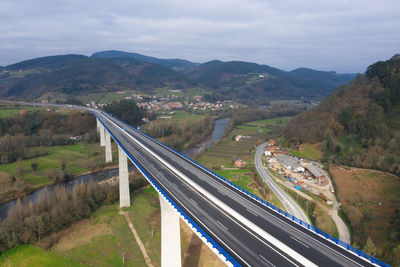 Aerial view of bridge over mountains against sky