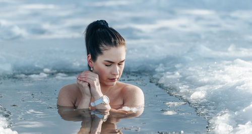 Side view of young woman drinking water