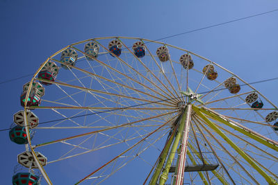 Low angle view of ferris wheel against blue sky