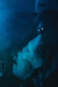 Portrait of young man smoking at home