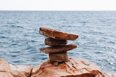 Close-up of rusty chain on beach against clear sky