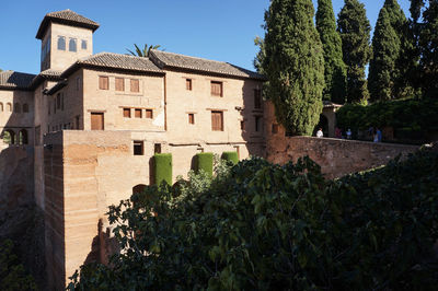 Alhambra fort by trees against clear sky