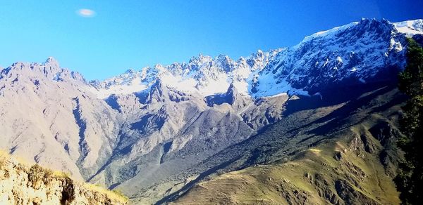 Scenic view of snowcapped mountains against clear blue sky