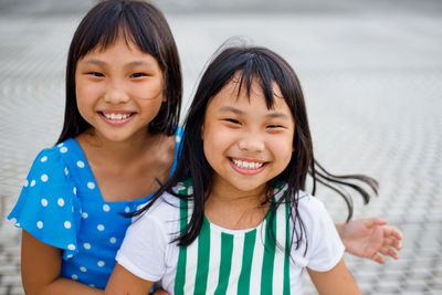 Portrait of smiling friends on footpath