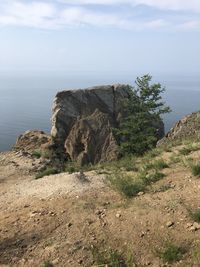 Rock formations by sea against sky