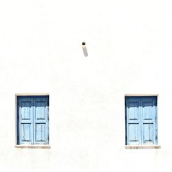 Closed wooden windows on white wall