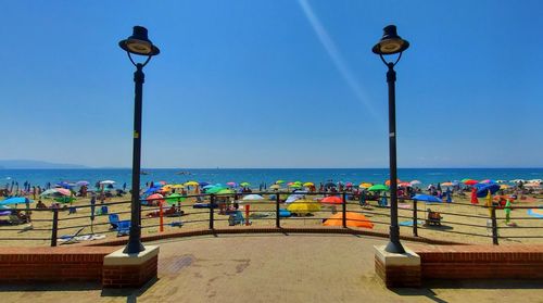 Street lights on beach against clear blue sky