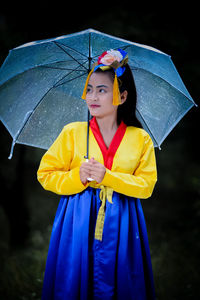 Portrait of young woman holding umbrella