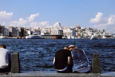 Rear view of man looking at cityscape against sky
