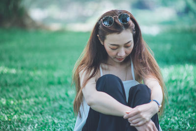 Beautiful woman sitting on field