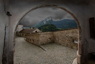 Old building by mountain against sky