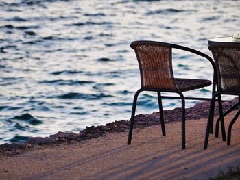 Empty chair on table by sea