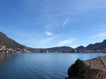 Scenic view of lake and mountains against blue sky