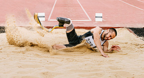 Male athlete falling on dirt