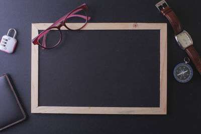 High angle view of eyeglasses and blackboard on table