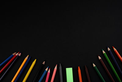 Close-up of colored pencils against black background