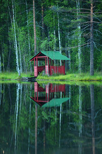 Built structure by lake against trees