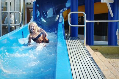 Cheerful girl enjoying on water slide