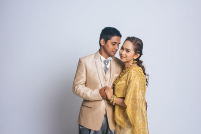 Young couple standing against white background