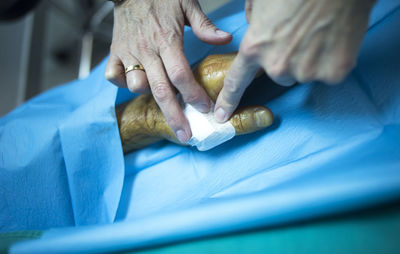 Cropped hands of doctor examining patient at hospital