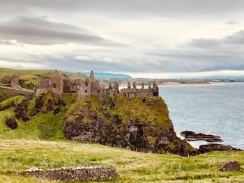 Old ruins of building by sea against sky