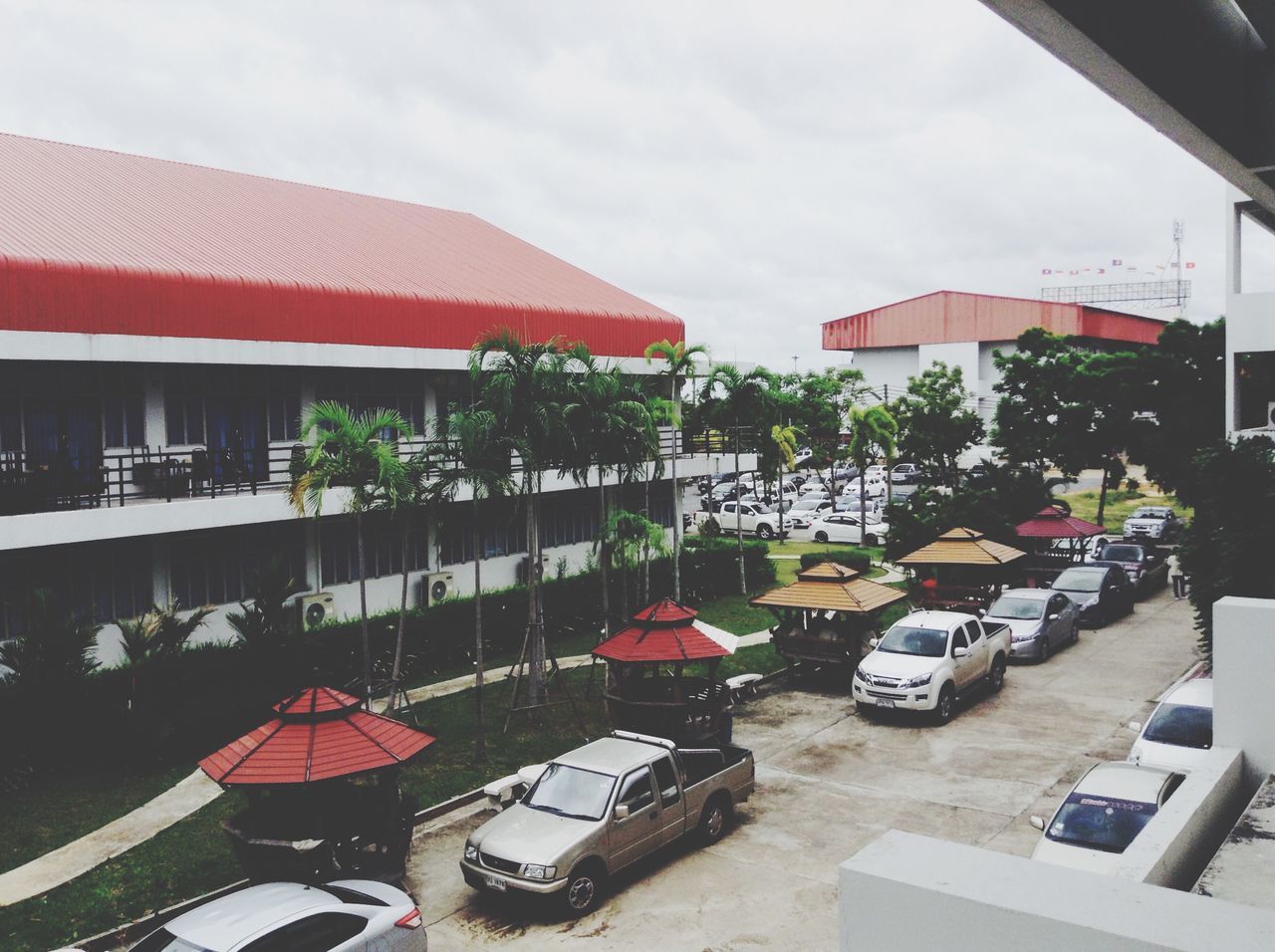 building exterior, architecture, built structure, sky, chair, transportation, mode of transport, car, in a row, incidental people, day, outdoors, city, land vehicle, cloud - sky, tree, absence, sunlight, house, street