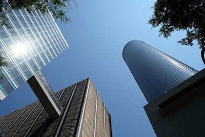 Low angle view of modern buildings against clear blue sky