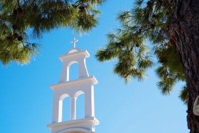 Low angle view of cross on building against sky