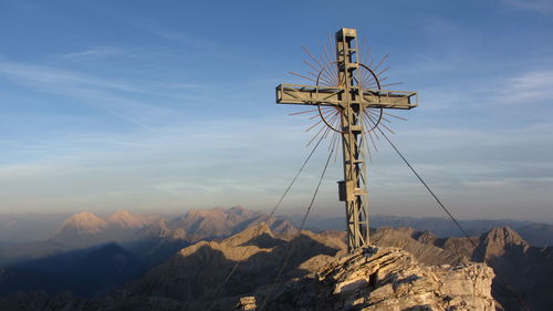 Cross on mountains against sky