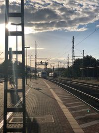 Railroad station against sky during sunset