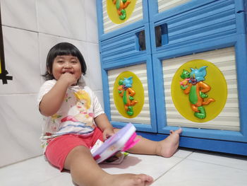 Cute girl sitting on floor at home