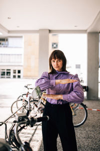 Portrait of smiling woman standing on bicycle