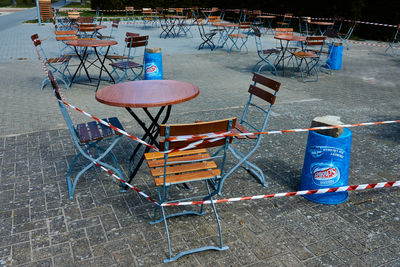 High angle view of empty chairs and tables at sidewalk cafe