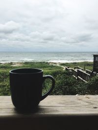 Table by sea against sky