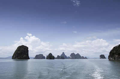 Scenic view of rocks in sea against blue sky