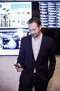 Mid adult businessman using mobile phone in office