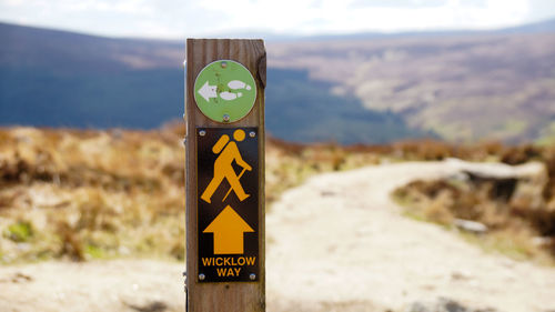 Close-up of road sign against mountains