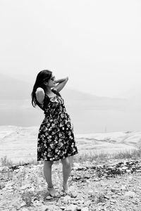 Woman standing on land against sky