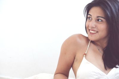 Portrait of a smiling young woman against white background