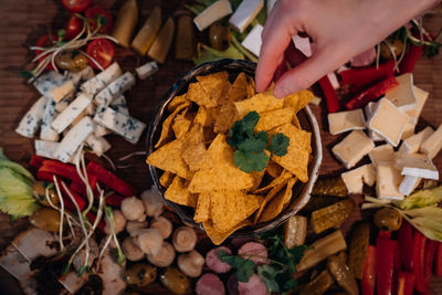 High angle view of food, cold cut board with nachos, cheese, ham and other snacks.