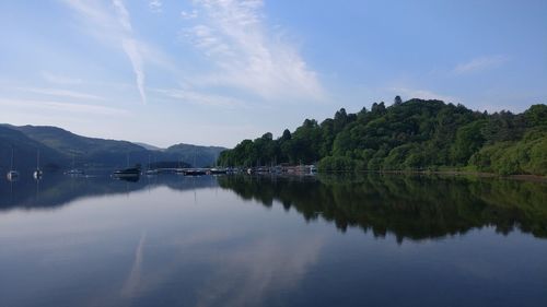 Scenic view of lake by trees against sky